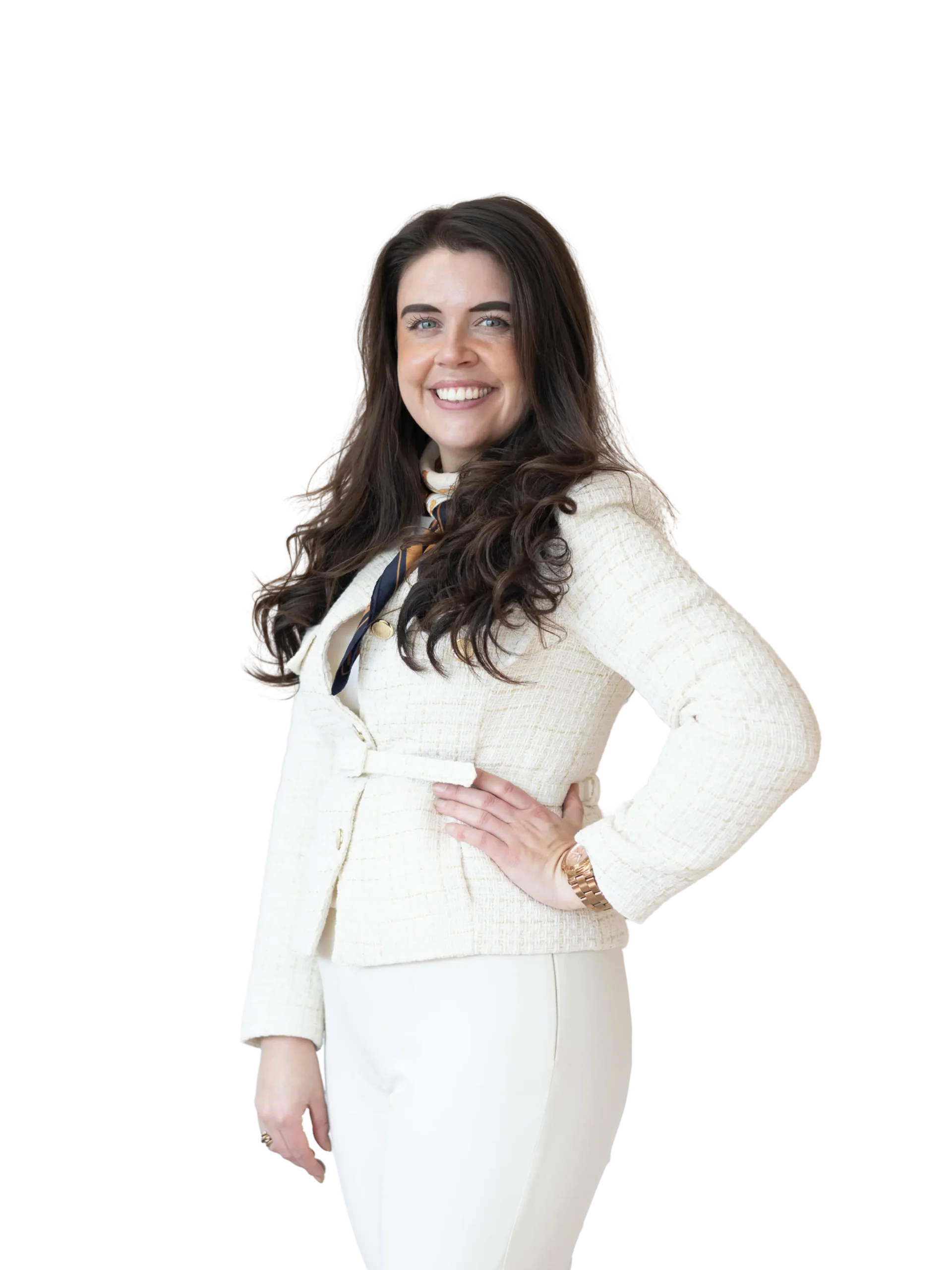 Glimlachende huidtherapeut van Huidskillskliniek met lang bruin haar, gekleed in een wit pak, staand met haar hand in de zij